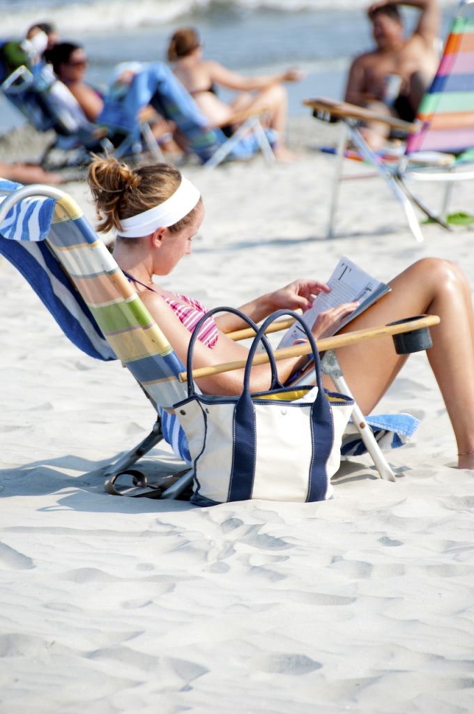 moça tomando sol na praia de perfil - o sol no pós operatório de rinoplastia